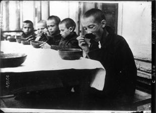La famine en Russie : dans une cantine, les enfants russes mangent la soupe que l’ARA vient de leur distribuer. Source: Gallica